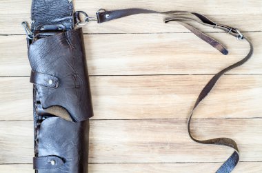 Ahşap bir masa üzerinde eski deri avcılık bandoleer