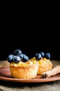 tartlets elma, üzüm ve tarçın bir kil plaka üzerinde