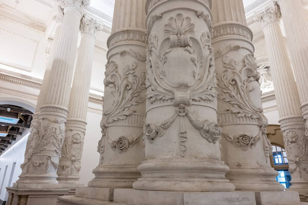 Крупный план украшенных колонн со сложной резьбой в Тайнаньском судебном музее. Белые колонны отображают детальные цветочные узоры и декоративные элементы.