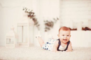 Güzel küçük kız, odadaki açık bir halıya uzanıyor.