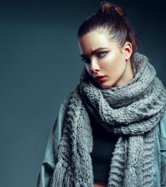 Stüdyoda makyaj ve saç stiliyle poz veren güzel elbiseli esmer manken..