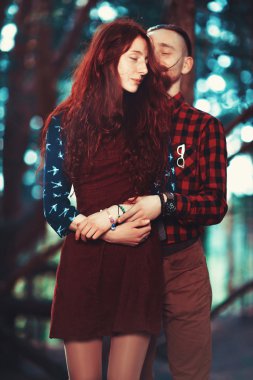 Kızıl saçlı adam, sakallı ve kıvırcık kızıl saçlı kız doğanın muhteşem manzarasının arka planında. Ormanda yürüyüşe çıkmış güzel bir çift..