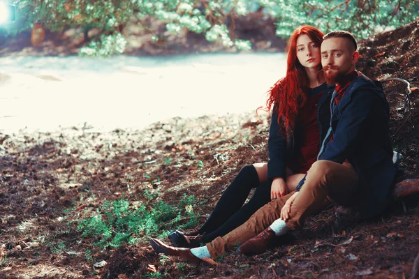 自然の素晴らしい景色を背景に 髭と巻き毛の少女を持つ赤い髪の男 森の中を歩く美しい恋人たち ロイヤリティフリーのストック写真