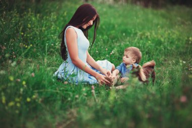 Güzel, mutlu bir aile doğada dinleniyor. İki kadın - annem ve teyzem parkta bir çocukla oynuyorlar. yumuşak odak
