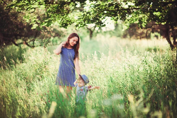 美しい幸せな家族は自然の中で休んでいます 母と息子が自然の中を歩く ソフトフォーカス — ストック写真