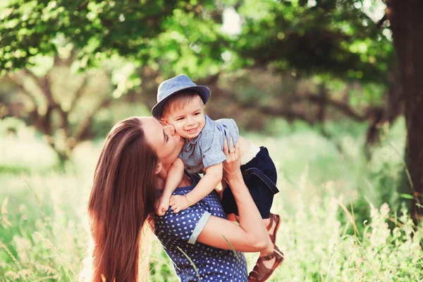 息子を抱いている母親を愛し 彼と遊び 彼を抱きしめる 家族は自然の中で休む ソフトフォーカス — ストック写真
