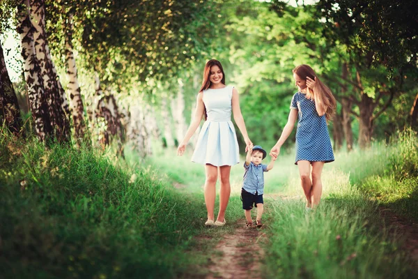 美しい幸せな家族は自然の中で休んでいます 母親と叔母の2人の女性は 森の中の歩道に沿って少年の手です ソフトフォーカス — ストック写真