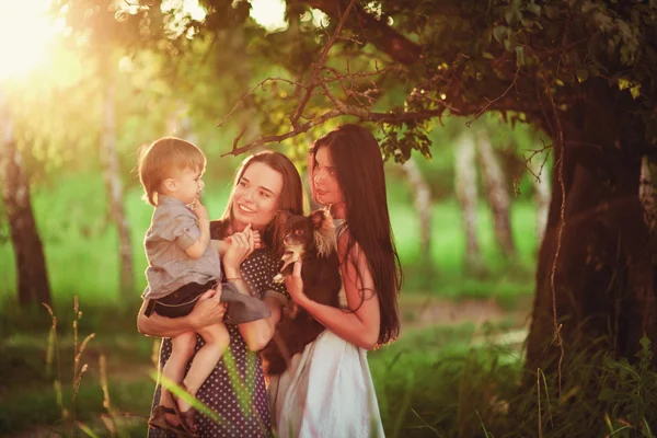 美しい幸せな家族は自然の中で休んでいます 公園で男の子と遊ぶ母親と叔母の2人の女性 ソフトフォーカス — ストック写真
