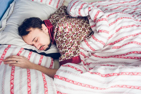 man  pajamas asleep in bed