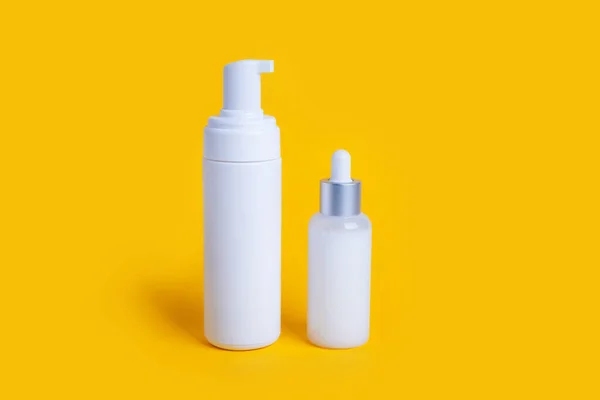 cosmetic bottles on yellow background with copy space