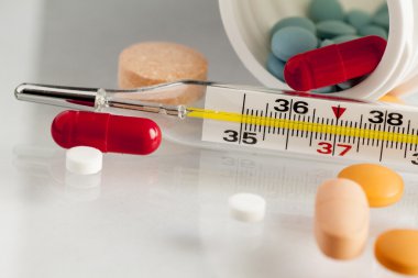 Beyaz arka plan üzerinde izole hapları ile termometre