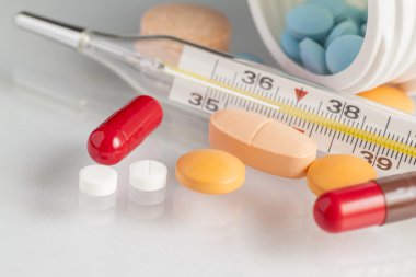 Beyaz arka plan üzerinde izole hapları ile termometre