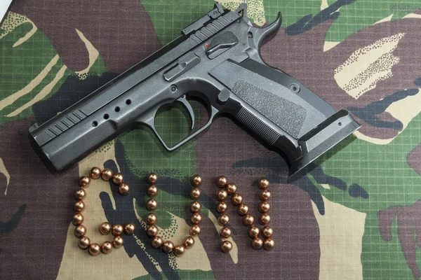Skjutvapen Pistol på militär camouflage bakgrund — Stockfoto