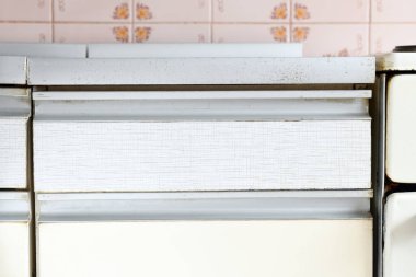 Eski bir mutfak mobilyası parçası. Tezgahın kenarı alüminyum bir profil ile budanmış. Eski beyaz mutfak. Alüminyum Profilli Mutfak Dolabı Kolları, Paslanmaz Çelik.