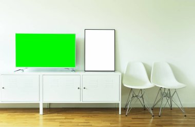 Geniş ekran yeşil ekran TV, beyaz bir duvara karşı krom bir ayakta duran metin ve video için..