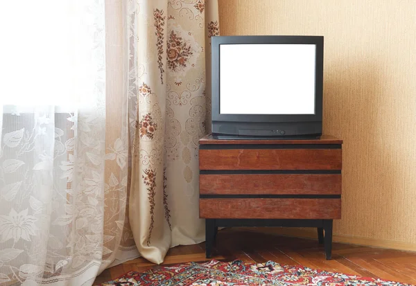 Antique TV with white screen on antique wooden cabinet, vintage design in 80s and 90s style house.