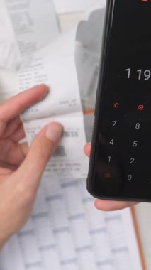 Mobil hesap makinesi, makbuzlar ve evrak işleriyle çevrili nakitle mali işlerle ilgilenen ellere yakın durun. Gider takibi, bütçe ve para yönetimine modern yaklaşım