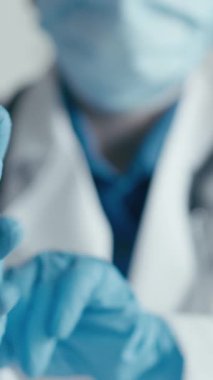 Bir sağlık çalışanı ameliyattan önce mavi eldivenleri dikkatlice giyer ve hasta korumasının gerekli olduğu klinik ortamlarda güvenlik ve hijyenin hayati önemini vurgular.