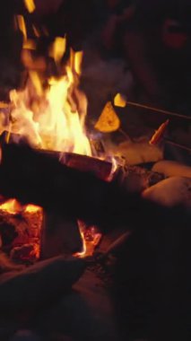 Yanıp sönen alevlerle dolu bir kamp ateşi sahnesi düşünün, yıldızlı bir gökyüzü, neşeli kahkahalarla toplanmış arkadaşlar, ve doğa etrafımızı sarmış, bu paylaşılan deneyimde sıcaklık ve derin bir bağ yaratıyor.