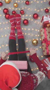 Noel hediyelerini zarifçe paketleyen parlak süslemeler, yanıp sönen ışıklar ve canlı ambalaj kağıtlarıyla çevrili neşeli bir bayramın ruhunu somutlaştıran bir kişinin olduğu festival sahnesi.