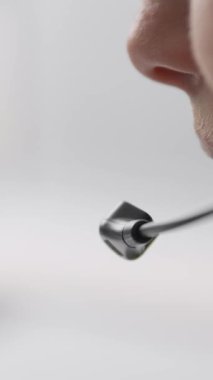 Uzaktan iletişimin, sanal yardımın ve müşteri hizmetleri etkileşimlerinin önemli yönlerini gösteren bir konuşmaya derinden odaklanmış, kulaklık takan bir kişinin samimi bir görüntüsü