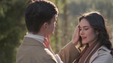 Sevgi dolu bir çift manzaralı bir ormanda birbirlerine yakın durur, samimi bir jesti paylaşırken neşe ve şefkat yayarlar. Dışarıdaki dingin ortam onların romantik atmosferini arttırıyor.