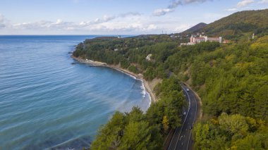 Deniz kıyısındaki tatil köyü, deniz kenarındaki dağ yolu, hava manzarası.