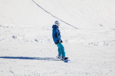 Bir kayak merkezinin açılışı, dağların arka planında snowboard yapan genç bir kız. Rusya, Soçi, Aralık 01, 2017.
