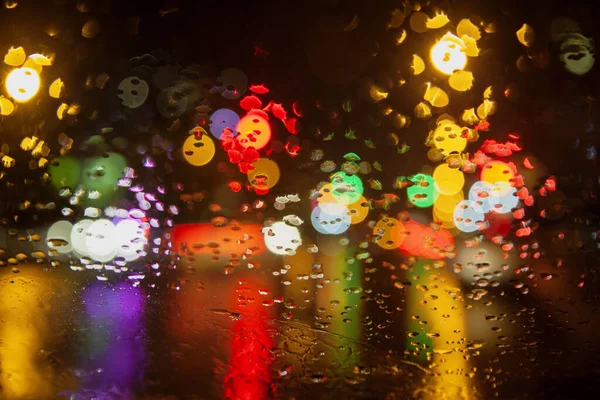 透过玻璃的雨滴 车灯和红绿灯的抽象背景 分散注意力 雨夜雨滴落在车窗上 模糊不清 — 图库照片