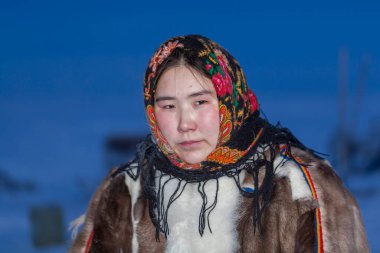 Genç kız, Kuzey Kutup Dairesi 'nin kuzey sakinlerinin ulusal kış kıyafetleri içinde.
