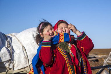 En kuzeyde Yamal, Nenets halkının geçmişi, kuzeydeki insanların evleri, tundrada yurt yakınlarında bir aile fotoğrafı.