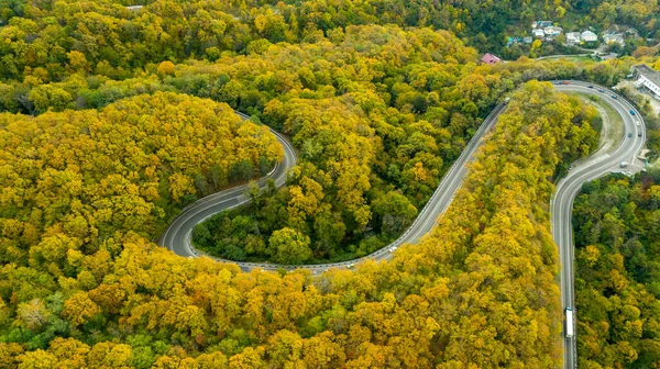 Smountain road along the sea, aerial vieweaside resort, Serpentine, aerial view of road along seaside of island with forest autumn on hill side back ground.