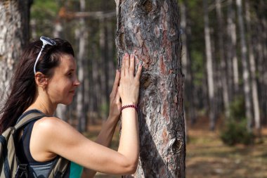 Ezoteriklik, bir kız başını bir ağaç gövdesine yasladı, asırlık bir çam ağacının enerjisi.