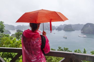 Halong Körfezi, Vietnam, şemsiye altındaki bir kız, gözlem güvertesinde duruyor, körfeze hayran.