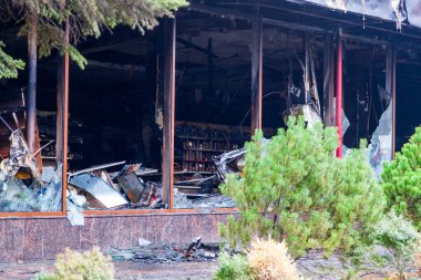 Yangın mahallinde itfaiye arabası olan bir ambulans, şehir merkezinde bir alışveriş merkezi, yanmış alışveriş merkezi, yıkıntı temizleme...