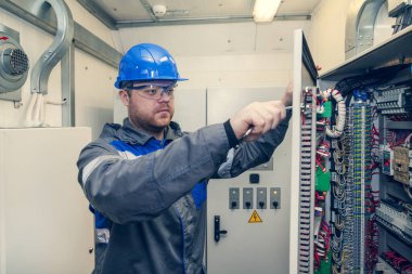 Elektrik ve enerji, elektrik paneli ile çalışan elektromekanik koruma, bir elektrikçi elektrik panelindeki elektrik dağıtım panellerini tanılar,.