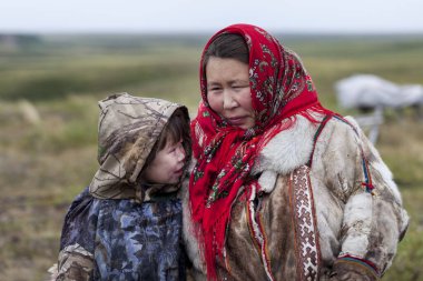 En kuzeyde Yamal, Nenets halkının geçmişi, kuzeydeki insanların evleri, tundrada yurt yakınlarında bir aile fotoğrafı.
