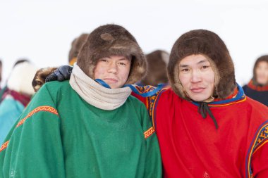 Far North, Yamal Peninsula, Day of the reindeer herder, local residents in national clothes of Nenets. Nadym, Russia - February 23, 2020 clipart