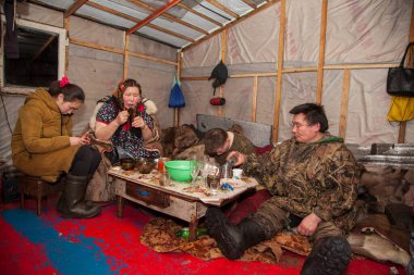 Kuzeyde Yamal, Nenet halkının otlakları, kuzeyde yaşayan insanların evleri, yurt, sanatsal tonlama, büyük aile yurtta çay içiyor. Nadym, Rusya - 6 Aralık 2020