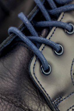 Esmer mavi erkek çizmeleri hakiki deriden, siyah bir arka plan, güzellik ve moda, yakın plan, dikey fotoğraf