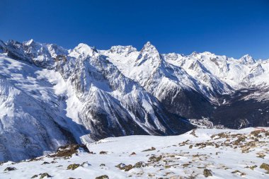 Kafkasya Dağları, Belalakaya, Sofrudzhu ve Sulakhat dağları ile kayak yamacının panoramik manzarası kış günü ufukta. Dombai kayak merkezi, Batı Kafkasya, Karachai-Cthe, Rusya.