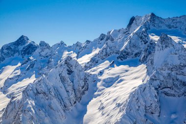 Kafkasya Dağları, Belalakaya, Sofrudzhu ve Sulakhat dağları ile kayak yamacının panoramik manzarası kış günü ufukta. Dombai kayak merkezi, Batı Kafkasya, Karachai-Cthe, Rusya.