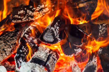 Kamp ateşi kömürleri, ızgarada odun yakma. Doku ateş közleri. Yanan ateş. Soyut arkaplan olarak odunların yakın plan yakılması. Yanan odun ateşinin kızgın közleri.