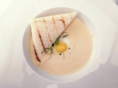 Restoranda servis edilen masa, vejetaryen yemeği, kereviz püresi çorbası, seçici odak, akıllı telefon fotoğrafı, gürültü.