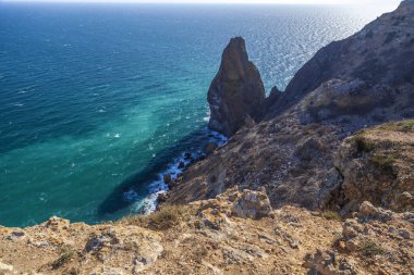 Kırım 'daki Karadeniz kıyısı, Sivastopol' daki Cape Fiolent manzarası. Panoramik deniz manzarası, sakin gök mavisi deniz, bulutlar ve parlak gökyüzü..