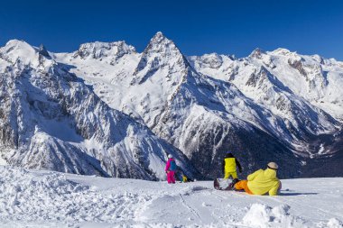 Kafkasya Dağları, Belalakaya, Sofrudzhu ve Sulakhat dağları ile kayak yamacının panoramik manzarası kış günü ufukta. Dombai Kayak Merkezi, Dombay, Rusya, 4 Mart 2021