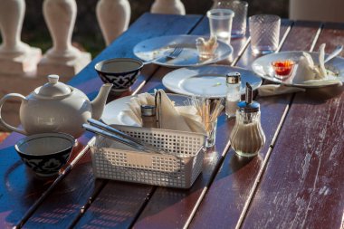 Sokak kafesindeki masada kirli tabaklar, yiyecek atıkları.