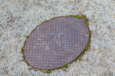 Eski dökme demir kapak yolda, Eski siyah dökme demir kapak asfaltta