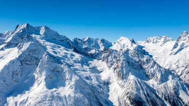 Kafkasya Dağları, Belalakaya, Sofrudzhu ve Sulakhat dağları ile kayak yamacının panoramik manzarası kış günü ufukta. Dombai kayak merkezi, Batı Kafkasya, Karachai-Cthe, Rusya.