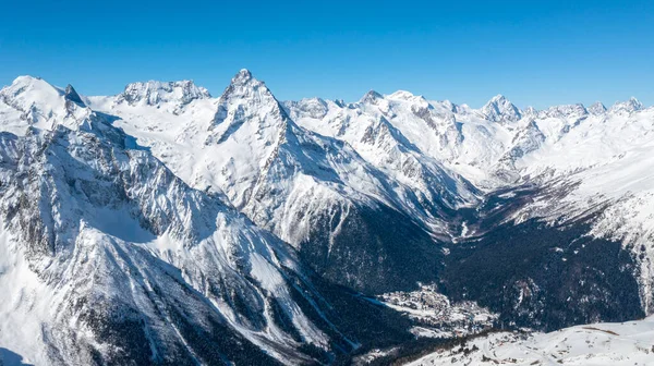 Kafkasya Dağları, Belalakaya, Sofrudzhu ve Sulakhat dağları ile kayak yamacının panoramik manzarası kış günü ufukta. Dombai kayak merkezi, Batı Kafkasya, Karachai-Cthe, Rusya.